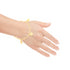 A close-up highlights a hand wearing the Hamsa Hand and Butterfly Charm Bracelet and Anklet, crafted from 14k gold-filled material with star and Hamsa Hand charms, set against a white background.
